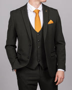 A man wearing an olive green check three-piece suit with a notch lapel, double-breasted blazer, and matching trousers. Accessorized with an orange tie and pocket square.