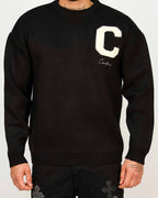 Front view of a men’s regular-fit black knit sweater with a varsity-style “C” chest patch and script embroidery.