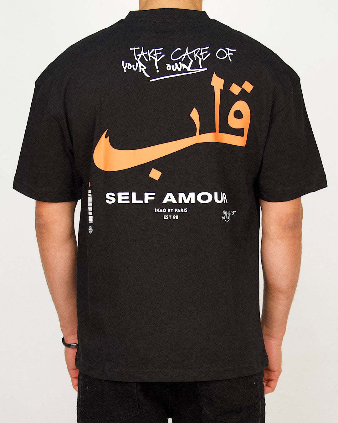 Back view of a men’s regular-fit black T-shirt with bold Arabic lettering and layered motivational text.