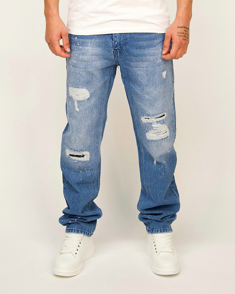 Blue straight-leg jeans with ripped panels and paint-splatter detailing.