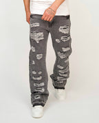 Men’s loose-fit grey denim jeans with heavy shredded distressing down both legs.
