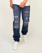Men’s relaxed-leg denim blue jeans with rip and paint-splatter detailing.
