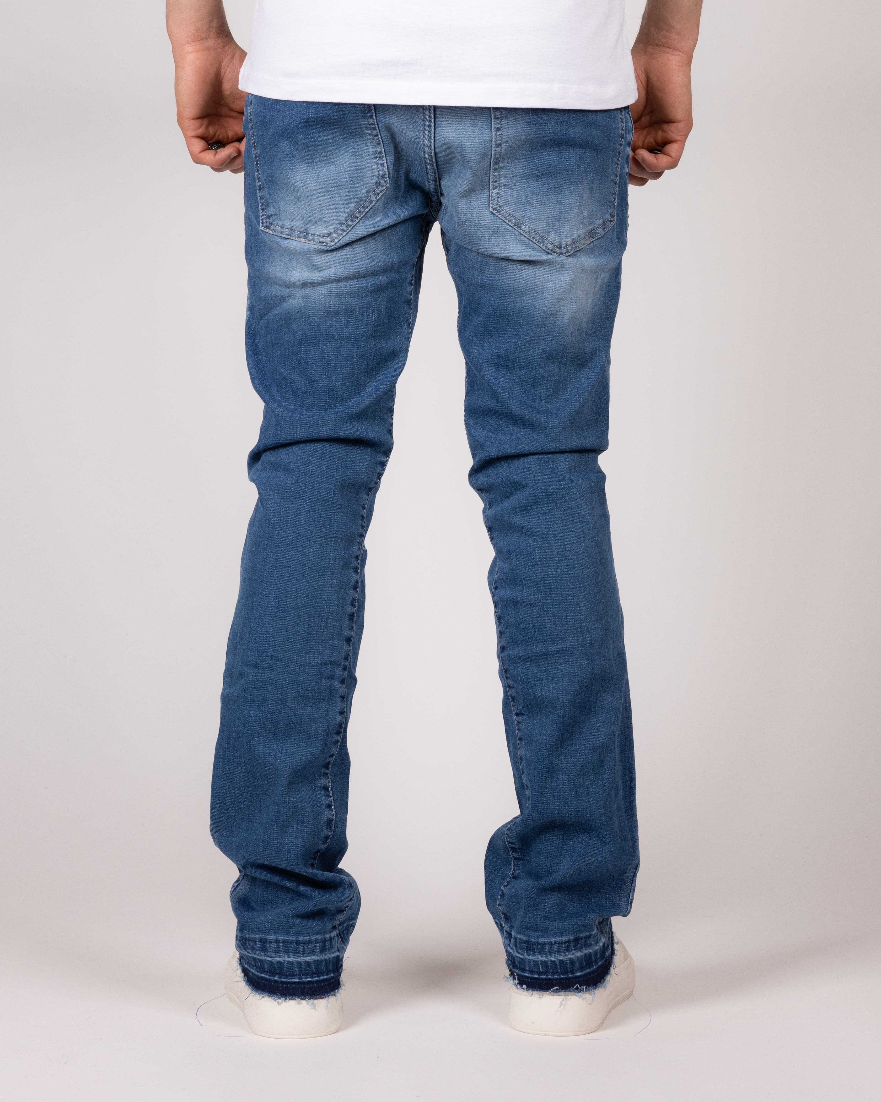 Washed Blue Flared Jeans With Raw Hem And Vintage Fade